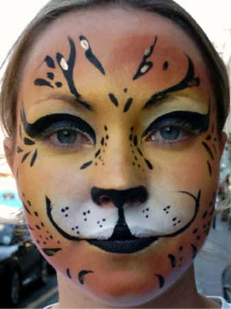 Face Painting: Adult female with antelope face on blended orange and yellow base.