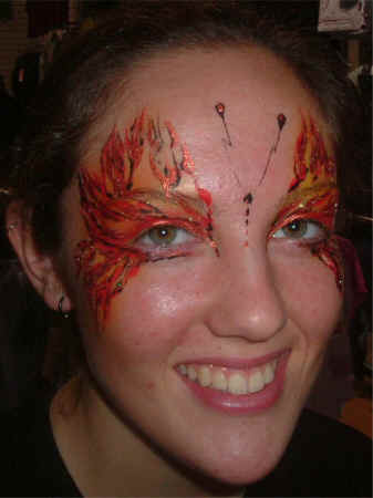 Face Painting: Adult female with full butterfly face in shades of orange.