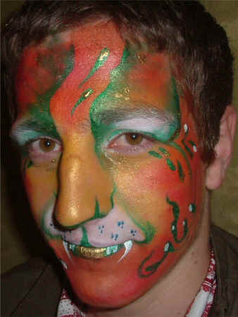 Face Painting: Adult male with orange and green tiger face.
